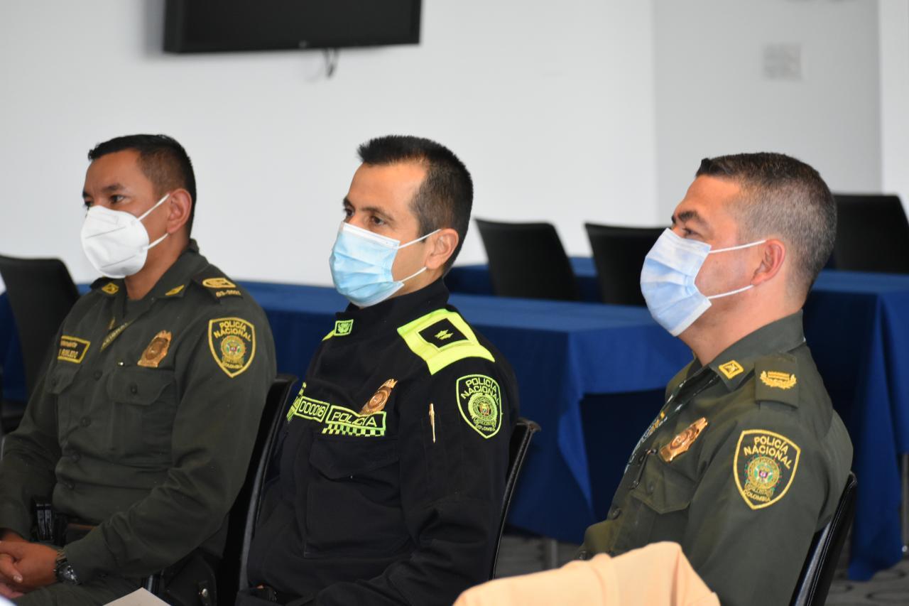 Three Colombian National Police sitting at table during Polus' Model Coherency human service program design workshop in Colombia.