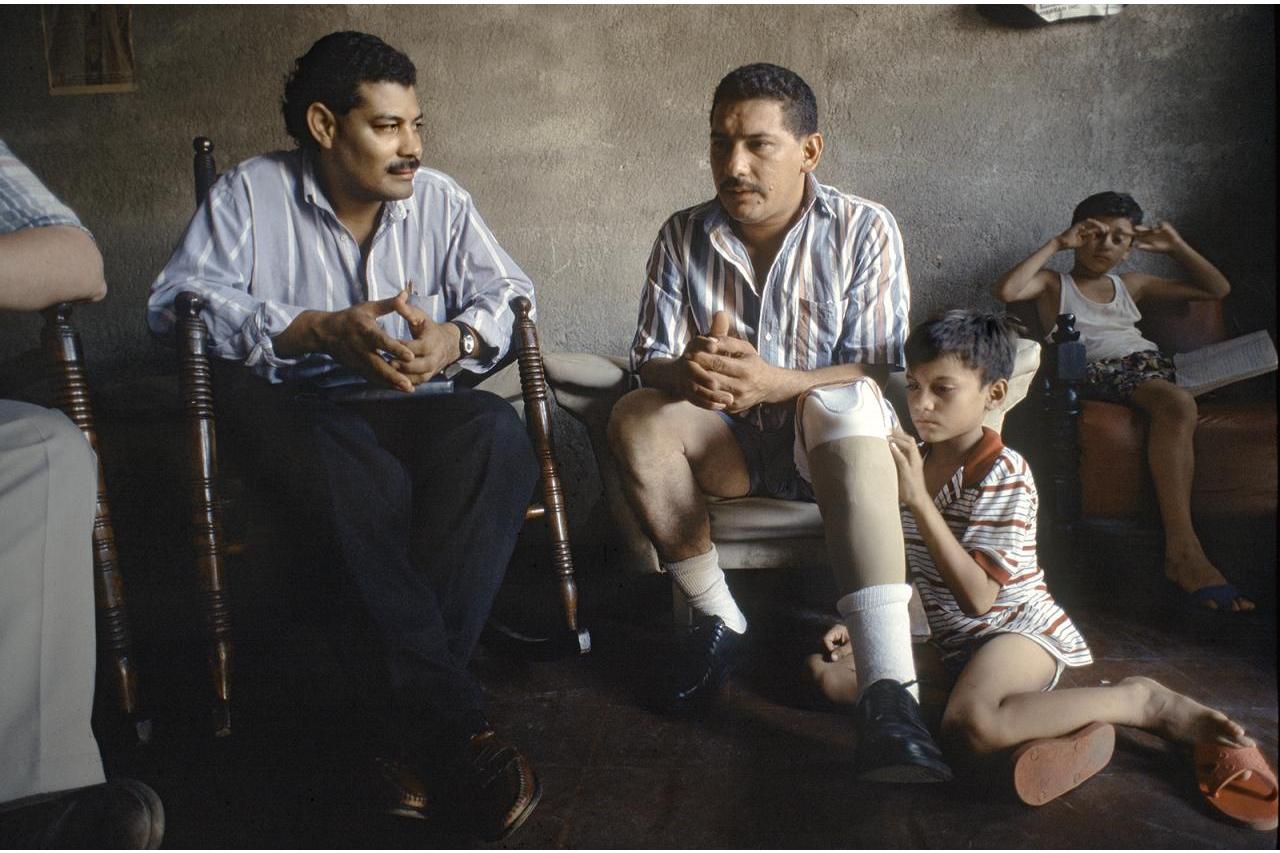 2 men seated talking with children (photo by Stephen Petegorsky)