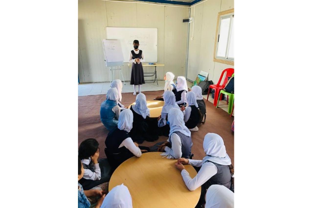 Teacher in front of classroom of young girls in Mosul, Iraq