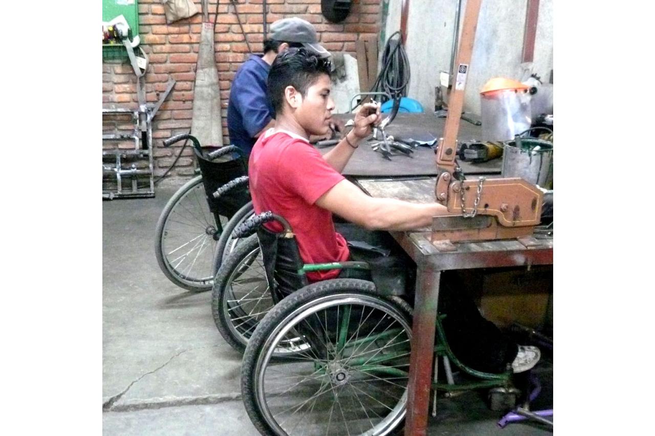 two men in wheelchairs building mobility devices (photo by Stephen Petegorsky)