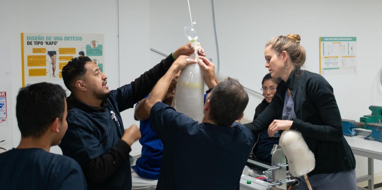 Prosthetic technicians and trainees building an artificial limb in Colombian prosthetic clinic. 