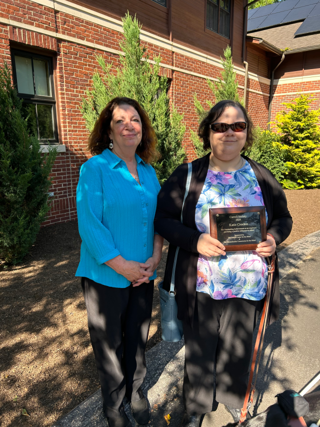 Katie Crocker holds her award with Executive Director Theresa Kane 